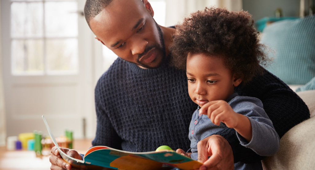 A parent reading with their toddler at bedtime